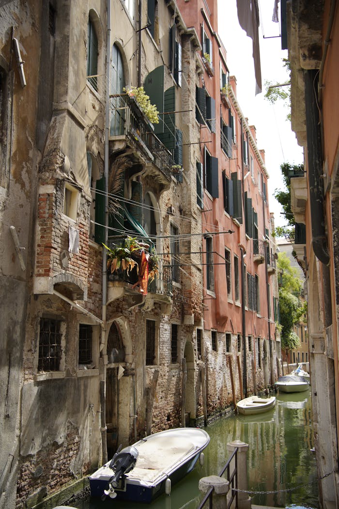 Picturesque view of a narrow canal in Venice with historic buildings and boats.